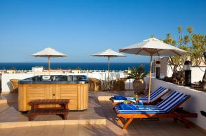 een patio met 2 stoelen en een hot tub bij Seaside Sandy Beach in Playa del Inglés