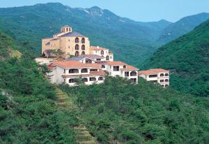 Club ES Jecheon Resort في جيتشيون: مجموعة مباني على تل به جبال