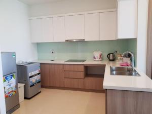 a kitchen with white cabinets and a sink and a refrigerator at 1504 Ha Long in Ha Long