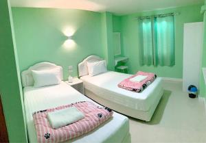 南府Lomluang hostel&hotel的小型客房 - 带两张床和绿色墙壁 更多7张照片