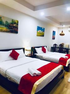 2 camas en una habitación con sábanas rojas y blancas en Ocean View TMS Luxury Apartment Quy Nhon, en Quy Nhon