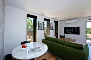sala de estar con sofá verde y mesa de cristal en 52Views Castlemaine, en Castlemaine