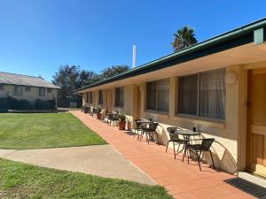 a patio with chairs and tables next to a building at The Aston Motel Tamworth in Tamworth