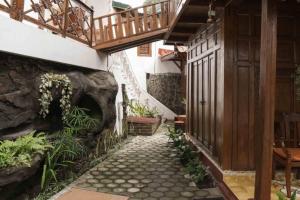 a walkway leading up to a house with a staircase at Rumah Kayu Joglo Yudhistira, tepi sungai, 2BR in Sleman
