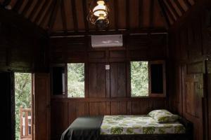 A bed or beds in a room at Rumah Kayu Joglo Yudhistira, tepi sungai, 2BR