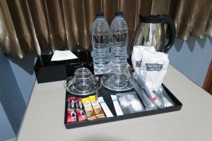 a tray with water bottles and other items on a counter at N.P. Apartment in Narathiwat