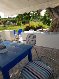 a blue table and a chair under an umbrella at Eleni B&B in Limánion