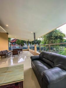 a living room with a leather couch and a table at AL Marina Resort in Puncak