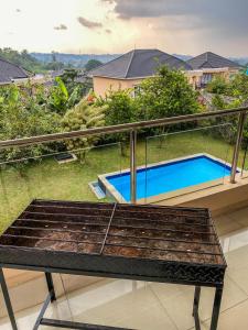 a balcony with a bench and a swimming pool at AL Marina Resort in Puncak