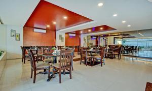 a restaurant with tables and chairs in a room at Treebo Trend Raj Elegance Nagavara in Bangalore