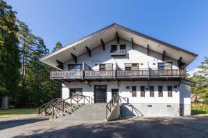 a white house with a balcony and stairs at THE CASTLE by Hakuba Hotel Group in Hakuba