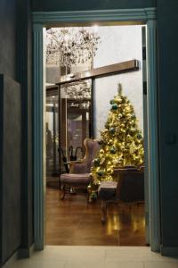 un arbre de Noël dans une pièce avec une chaise dans l'établissement Отель "Даймонд Луговая", à Koursk