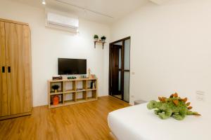 1 dormitorio con 1 cama y TV en una habitación en Xiao Dong Quiao Yu, en Yilan City