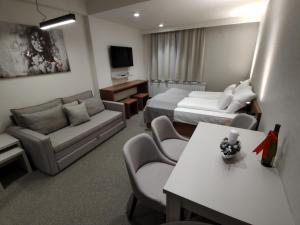 a hotel room with two beds and a couch at Star Hill - Koznik Konaci in Kopaonik