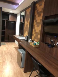a room with a desk with a computer and a television at Thalang resort in Thalang