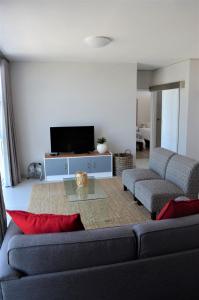 ein Wohnzimmer mit einem Sofa und einem Tisch in der Unterkunft 604 St Tropez in Strand