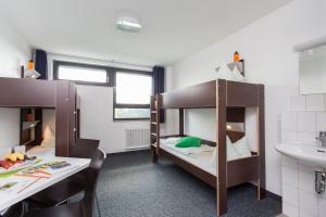 a room with two bunk beds and a sink at Jugendherberge City-Hostel Köln-Riehl in Cologne