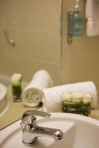 a bathroom sink with a faucet in front of a mirror at Leonardo Hotel Aberdeen in Aberdeen