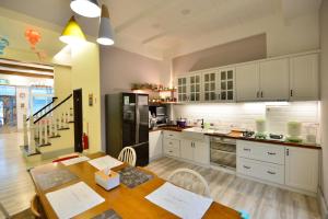 a kitchen with white cabinets and a wooden table with a tableablish at Happiness Childhood in Hualien City