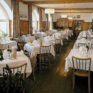 uma sala de jantar com mesas e cadeiras brancas em Hotel Passo Stelvio em Passo Stelvio