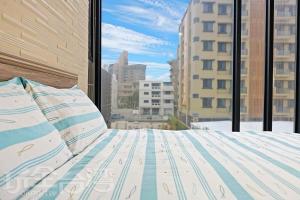 a bed in a room with a view of a city at Penghu 123 V-Stone in Magong