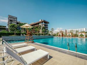 - une piscine avec un fauteuil et un parasol dans l'établissement 1 Hotel Haitang Bay, Sanya, à Sanya