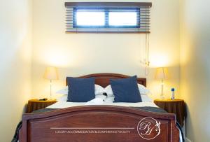 a bedroom with a bed with blue pillows and a window at Roseland House in Durban