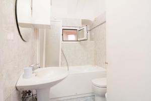 a white bathroom with a sink and a toilet at Casa del Borgo in Finale Ligure +13 photos