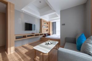 a living room with a couch and a tv at Shanghai Baixia Pagoda Hotel in Shanghai