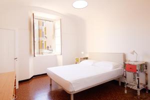 a bedroom with a white bed and a window at Casa del Borgo in Finale Ligure
