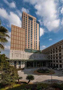 a tall building with a parking lot in front of it at Shanghai Baixia Pagoda Hotel in Shanghai