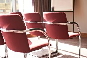 a row of red chairs in a room at Leonardo Hotel Aberdeen in Aberdeen
