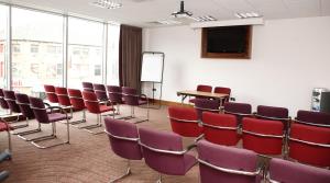 a room with chairs and a table and a screen at Leonardo Hotel Aberdeen in Aberdeen
