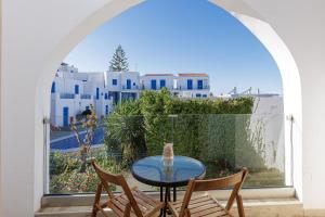 una mesa y sillas en un balcón con vistas al océano en Kasteli Studios & Apartments, en Panormos Rethymno