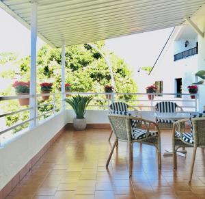 um alpendre com cadeiras e uma mesa na varanda em Casa de la Playa em Vega de Espinareda