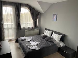 a bedroom with a bed with a bow on it at Ski Apartment Boyika Iglika 2 in Borovets