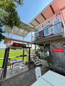 a house with a balcony and a table and chairs at Slowlife House Ayothaya in Phra Nakhon Si Ayutthaya