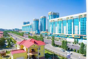 a city with tall buildings and a street with cars at Cozy apartment on Sarayshyq street 5E in Astana