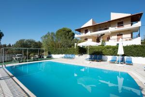 a swimming pool in front of a building at Cochelli Villas in Kassiopi