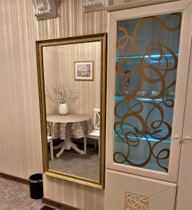 a mirror next to a table in a room at Hotel Lux Angliter in Vologda