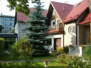 a house with a pine tree in the yard at Nepi Hotell in Tallinn