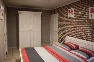 um quarto com uma cama e uma parede de tijolos em Breeden Steeger Hoeve em Lichtervelde