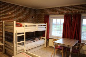 een kamer met 2 stapelbedden en een tafel bij Breeden Steeger Hoeve in Lichtervelde