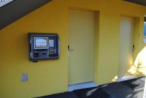 a television on a wall next to a door at Hotel Du Soleil in Saint-Léonard