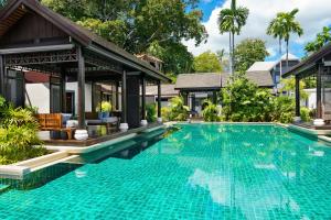 a swimming pool in front of a villa at Anantara Lawana Koh Samui Resort in Chaweng