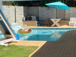 a swimming pool with an umbrella and an inflatable at Apartment on Constance Road in Springfield