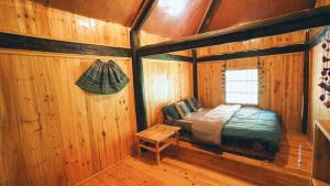 サパにあるJoy House Indigo Batikの木造キャビン内のベッド1台が備わるベッドルーム1室を利用します。