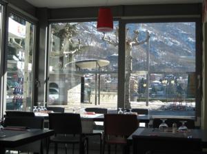 ein Restaurant mit Tischen und Stühlen und einem großen Fenster in der Unterkunft Albergo Ristorante Pomodoro in Omegna