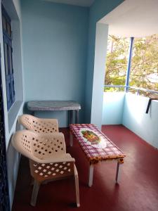 um quarto com uma mesa e uma cadeira e um banco em Cherry Blossom em Pondicherry