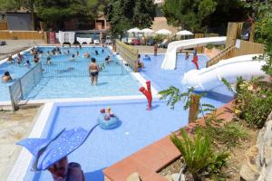 Camping Sènia Cala Canyelles في يوريت دي مار: مسبح كبير مع وجود أشخاص في الحديقة المائية